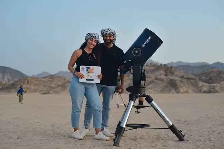 Guests with telescope at Sharm El-Sheikh desert camp, add-on stargazing after ATV, camel ride and BBQ show