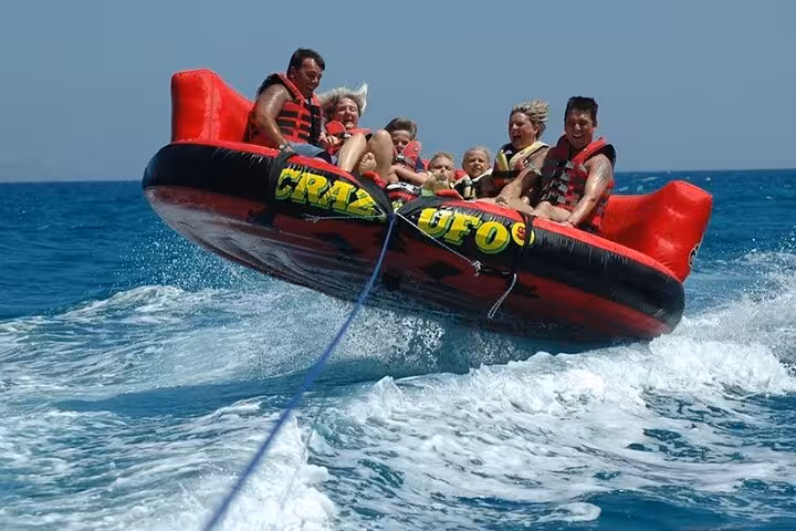 Family on Crazy UFO towable tube in Sharm El Sheikh, Red Sea waves ride on Mega Safari Waves and Dunes tour