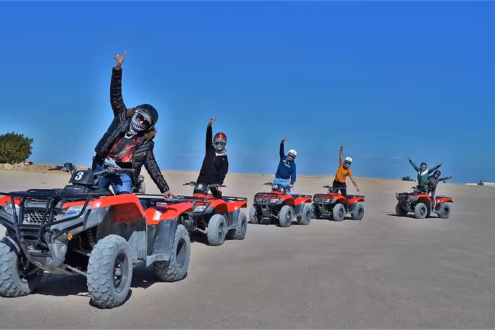 Group riding quad bikes in Sharm El Sheikh desert safari, ATV adventure before stargazing and Bedouin BBQ dinner