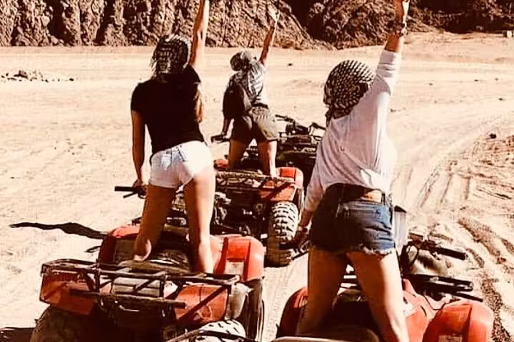 Riders on quad bikes in Sinai desert during Sharm El Sheikh Bike Camel Canyon Tour off-road safari
