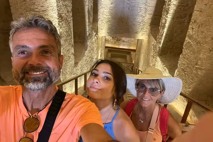 Travelers selfie inside ancient Luxor tomb on Sharm to Luxor by plane sharing group day tour