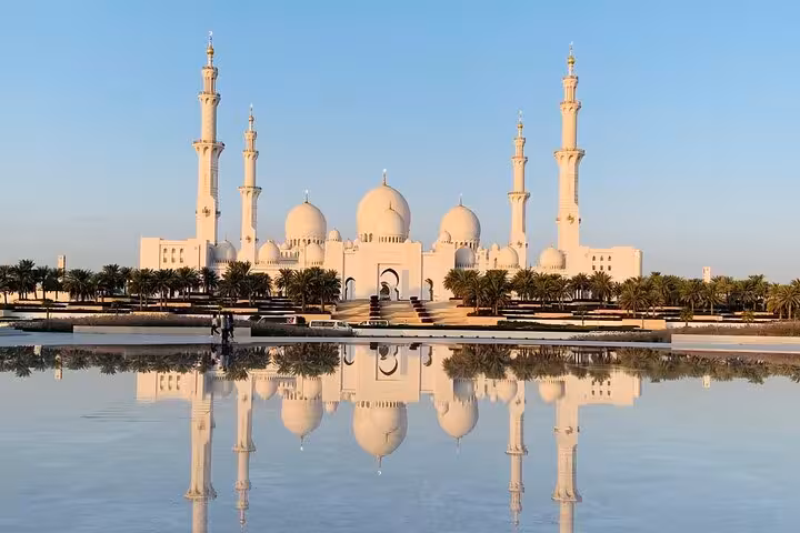 Stunning Sheikh Zayed Grand Mosque with four minarets perfectly reflected in calm waters in Abu Dhabi