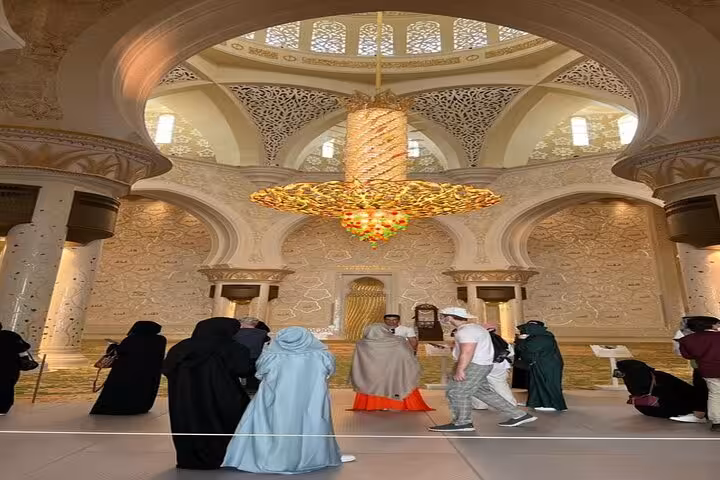 Sheikh Zayed Grand Mosque courtyard glowing blue at night, ideal for sunset visit Abu Dhabi tour