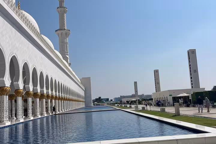 Sheikh Zayed Grand Mosque white marble colonnade with reflective pool during Abu Dhabi full-day tour