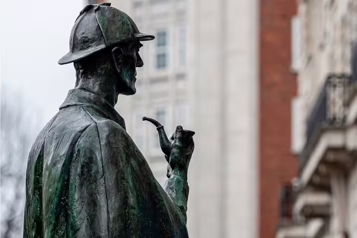 Bronze statue of Sherlock Holmes holding a pipe, wearing deerstalker hat, London backdrop