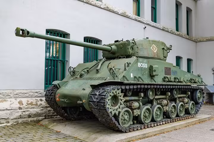 WWII Sherman tank on display at Normandy D-Day museum, painted olive green with 'BOSS' markings