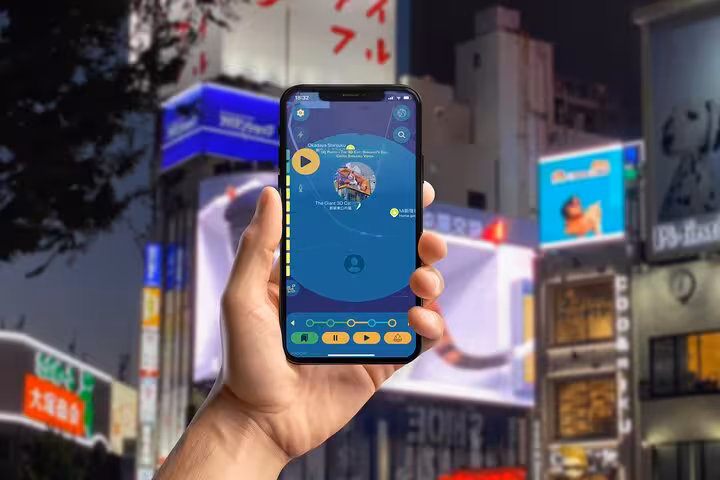 Hand holding smartphone displaying Shinjuku self-guided walking tour app with neon city lights in background