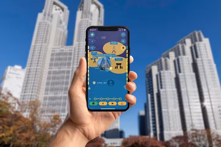 Hand holding smartphone with Shinjuku self-guided walking tour app, Tokyo skyscrapers in background