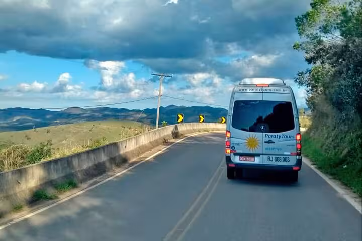 Scenic road journey in a shuttle van heading towards Ilha Grande with picturesque landscapes in view.