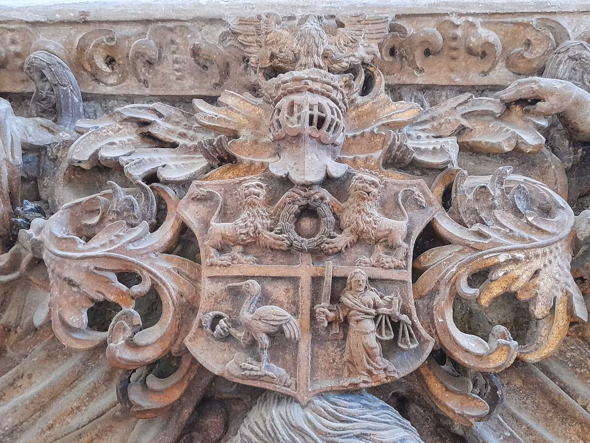 Detailed stone coat of arms carving on historic Sibiu cathedral wall visited during Corvin Castle day trip from Cluj