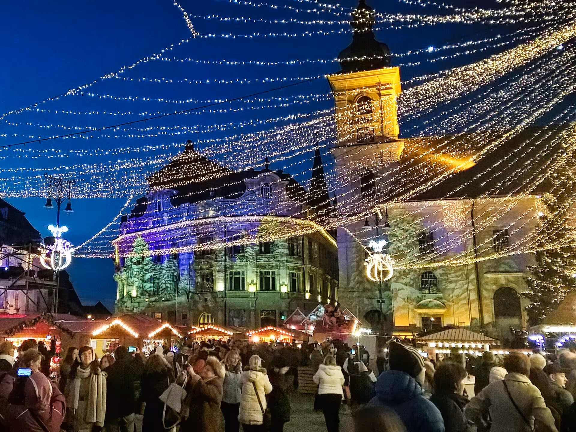 Sibiu Christmas market at night with festive lights and historic buildings in the main square