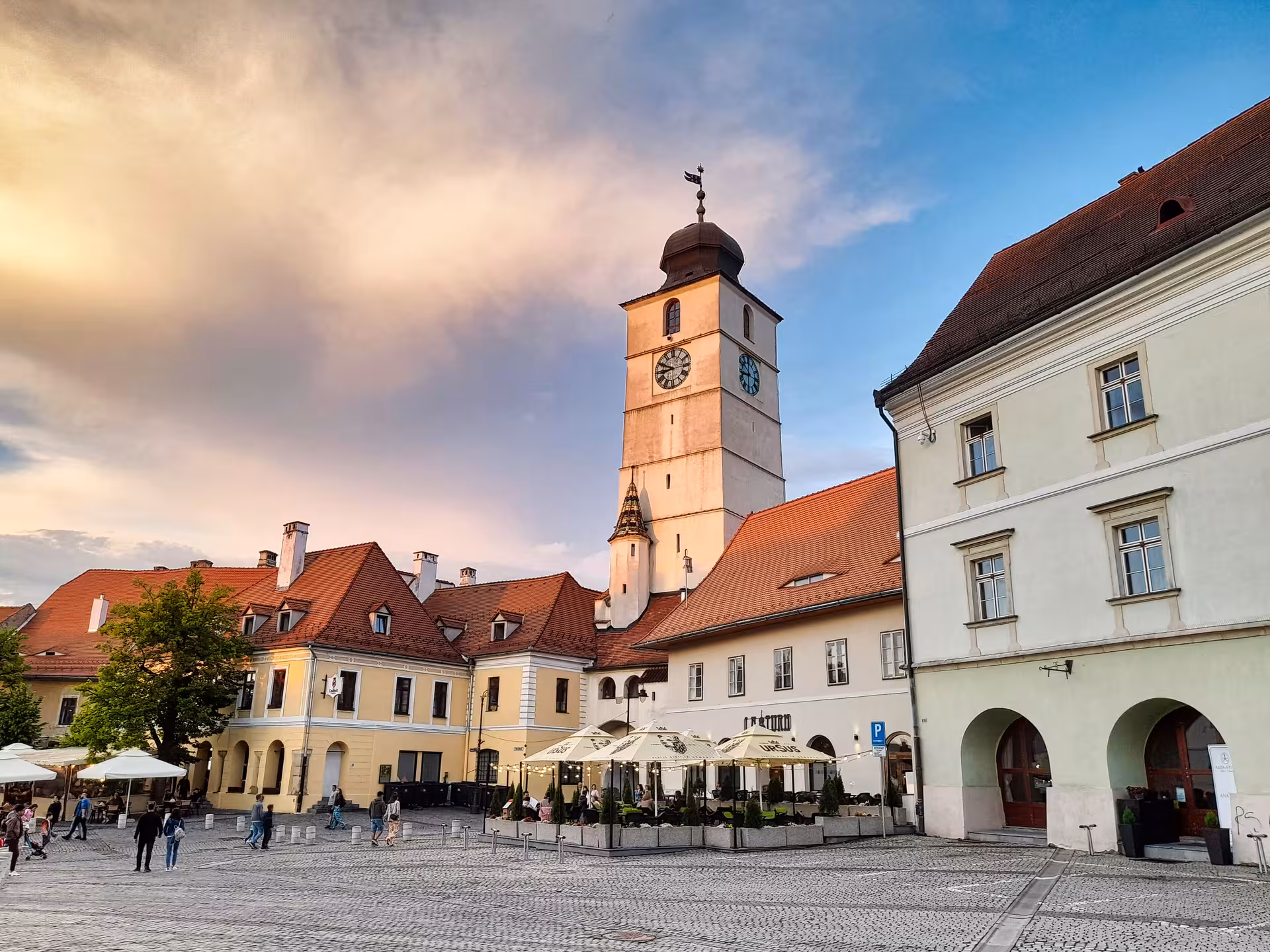 Sibiu Council Tower rising above the cobblestone Small Square on a Corvin Castle day trip from Cluj-Napoca