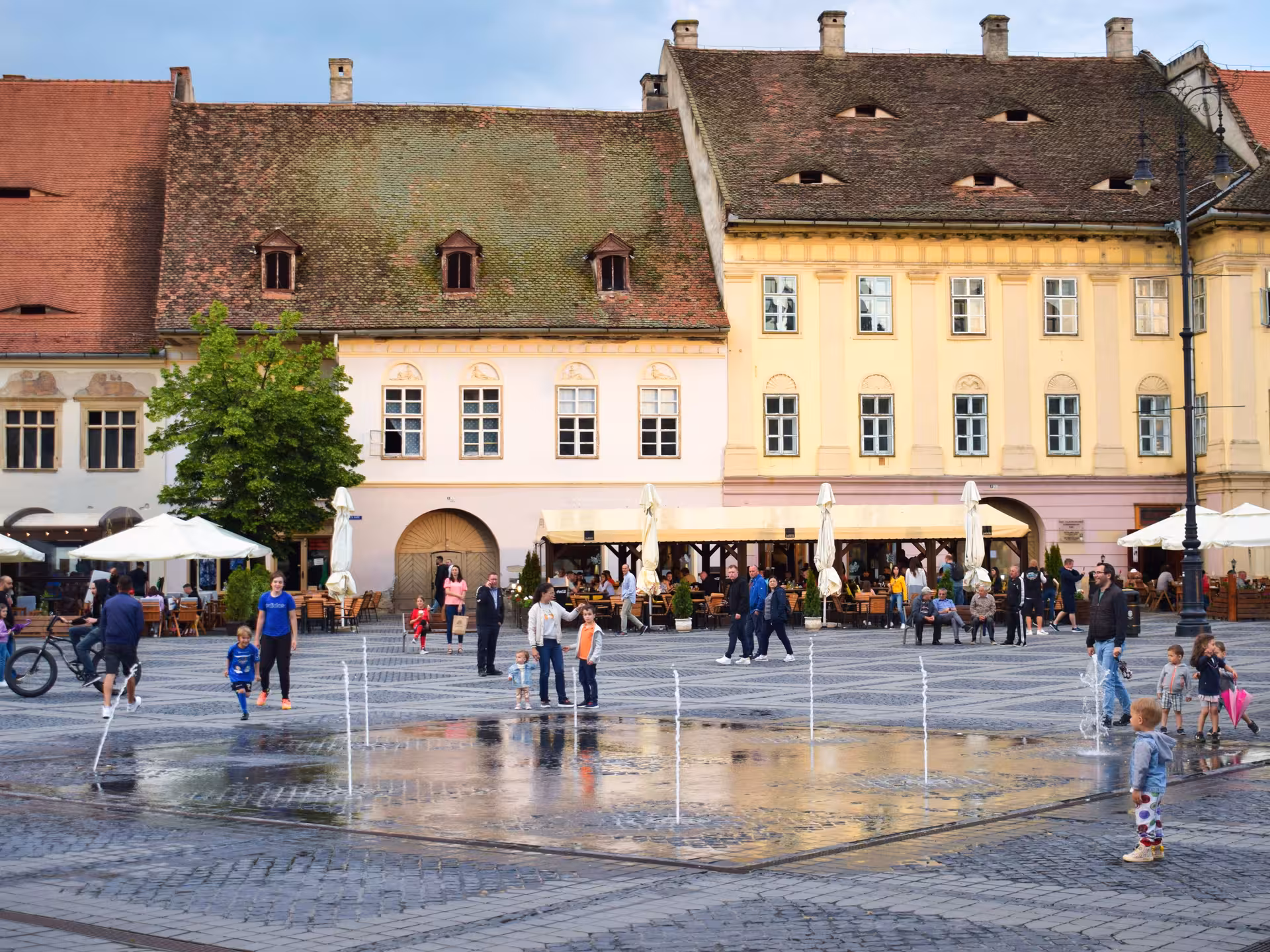 Lively Grand Square of Sibiu with fountains and colorful Saxon buildings on a Cluj-Napoca day tour