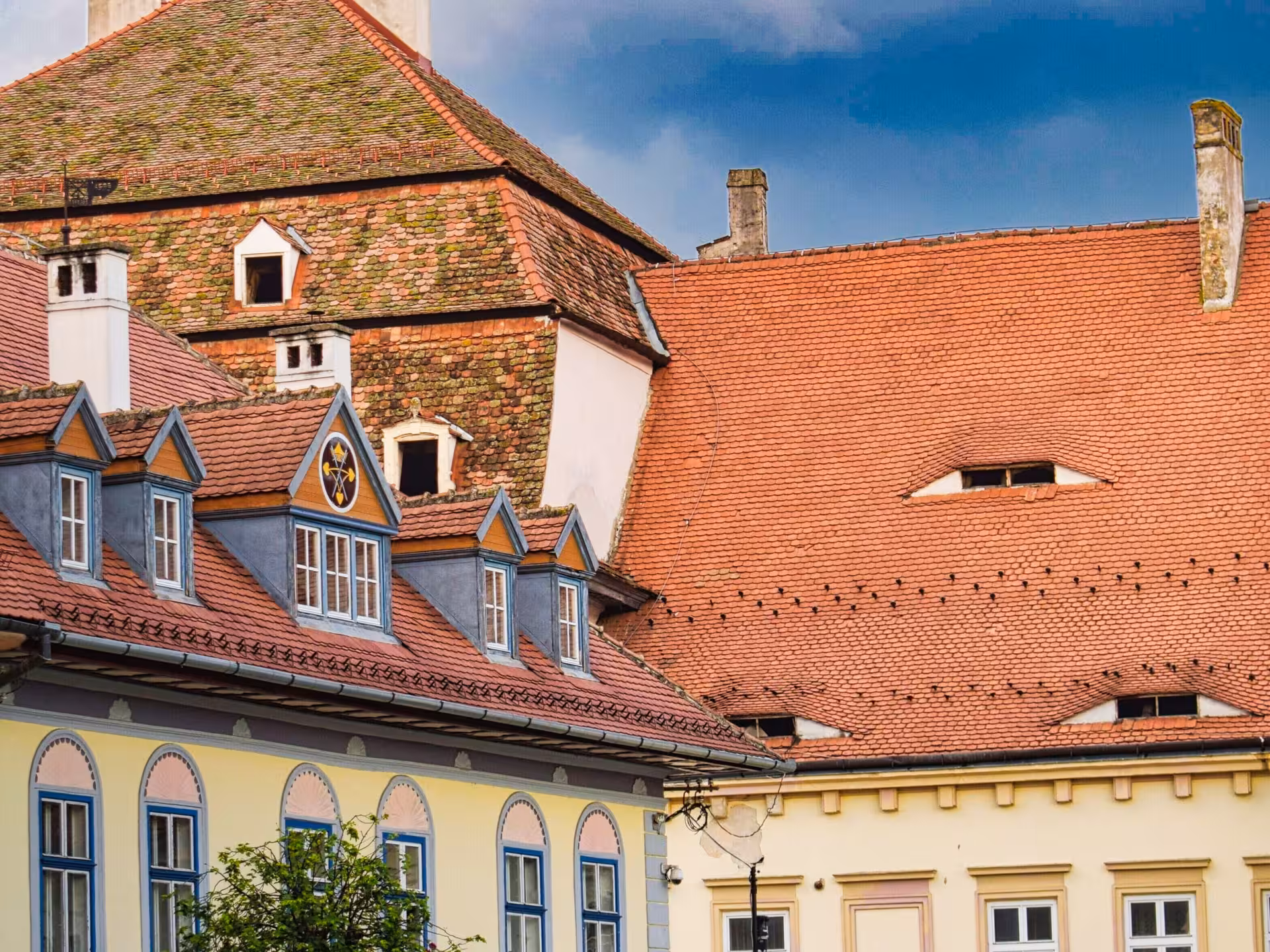 Historic baroque buildings with red terracotta tile roofs and dormer windows in Sibiu, Romania