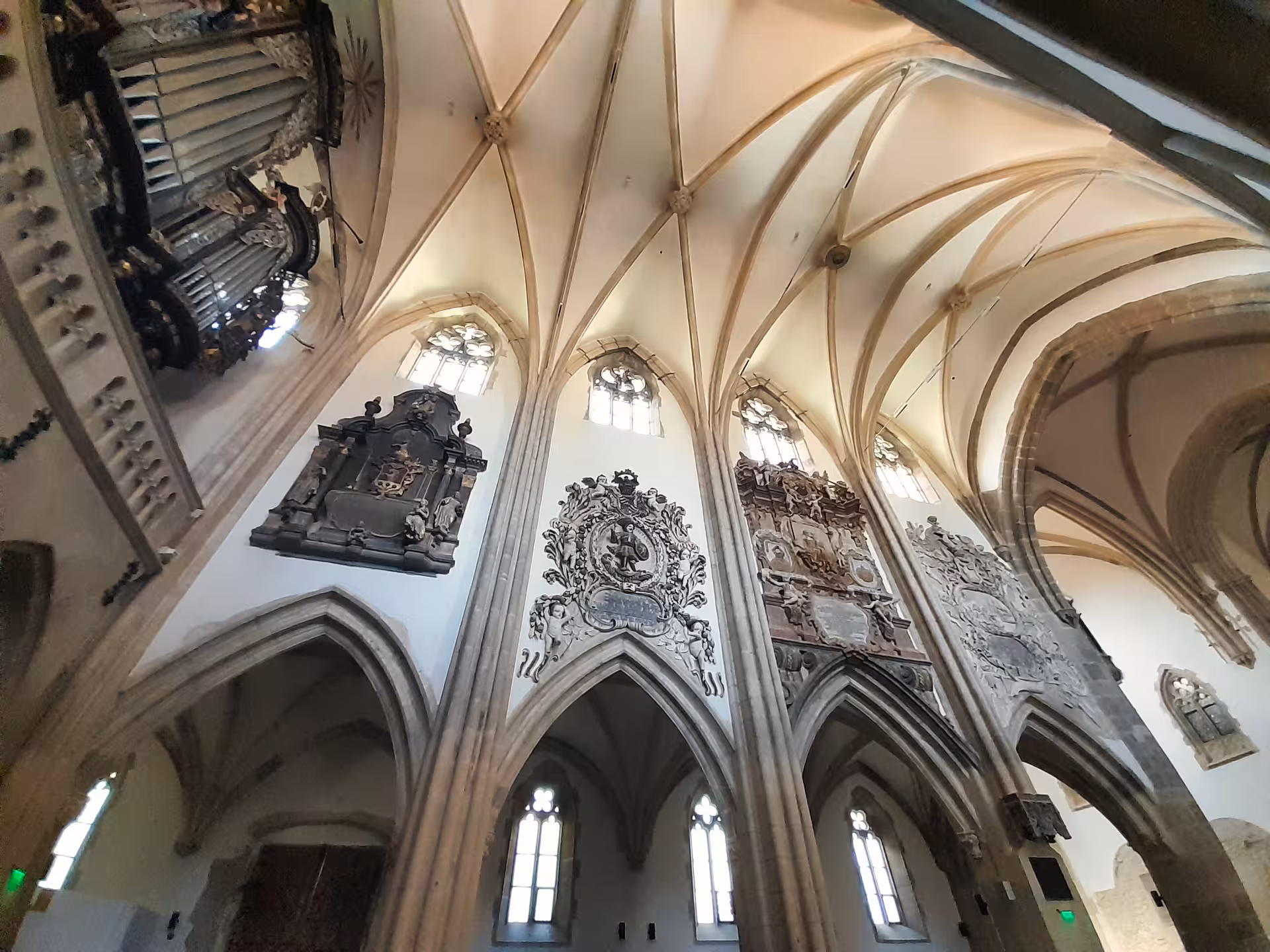 Gothic vaulted ceiling with ornate baroque epitaphs inside Sibiu Lutheran Cathedral on a day trip from Cluj-Napoca