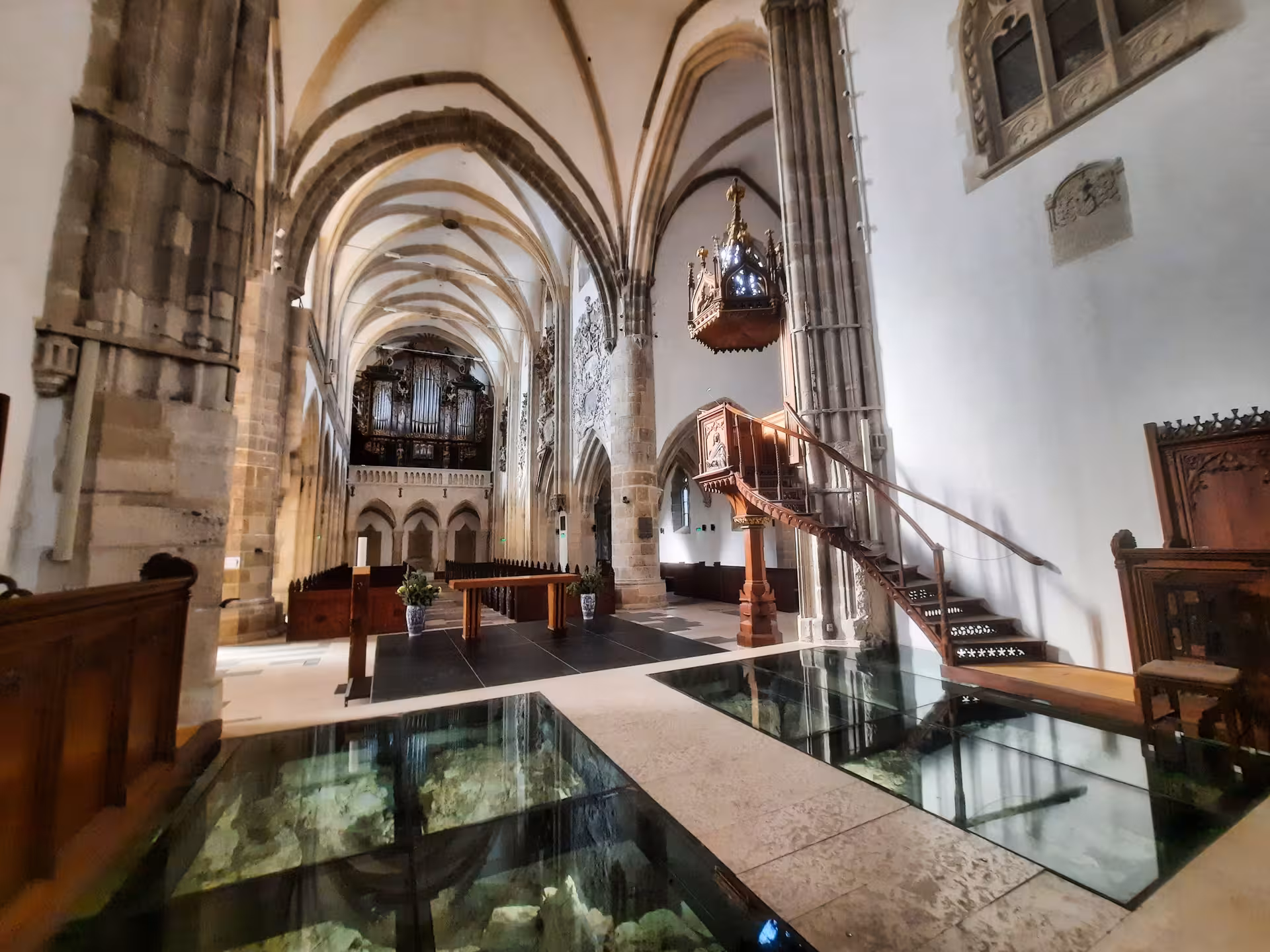 Grand nave of Sibiu Lutheran Cathedral featuring glass floor ruins organ and pulpit on Cluj-Napoca day tour