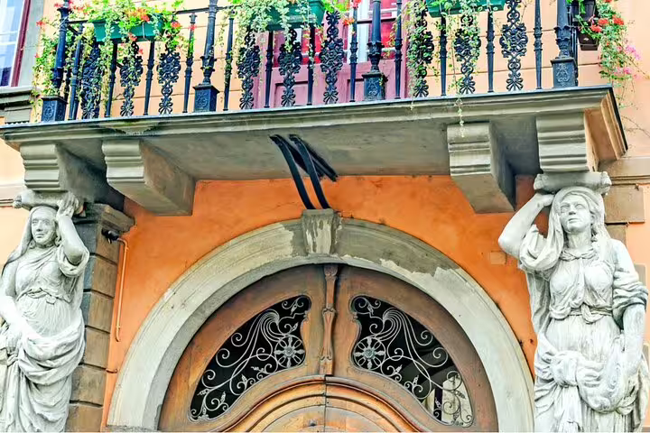 Ornate building entrance with caryatid statues and decorative balcony in Sibiu Old Town