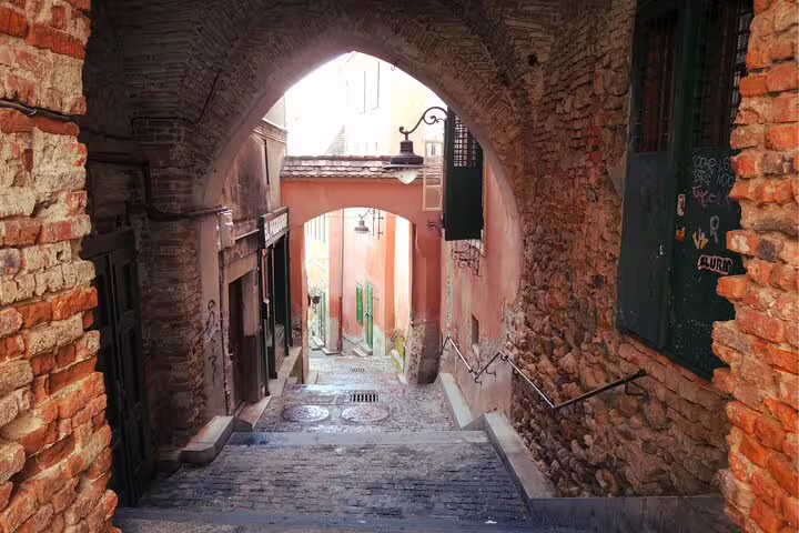 Medieval stone archway leading through a narrow cobblestone alley in Sibiu Old Town, Romania