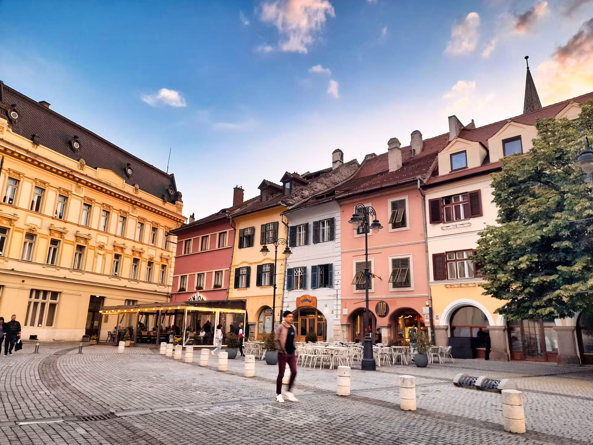 Colorful historic buildings and cobblestone square in Sibiu old town at sunset