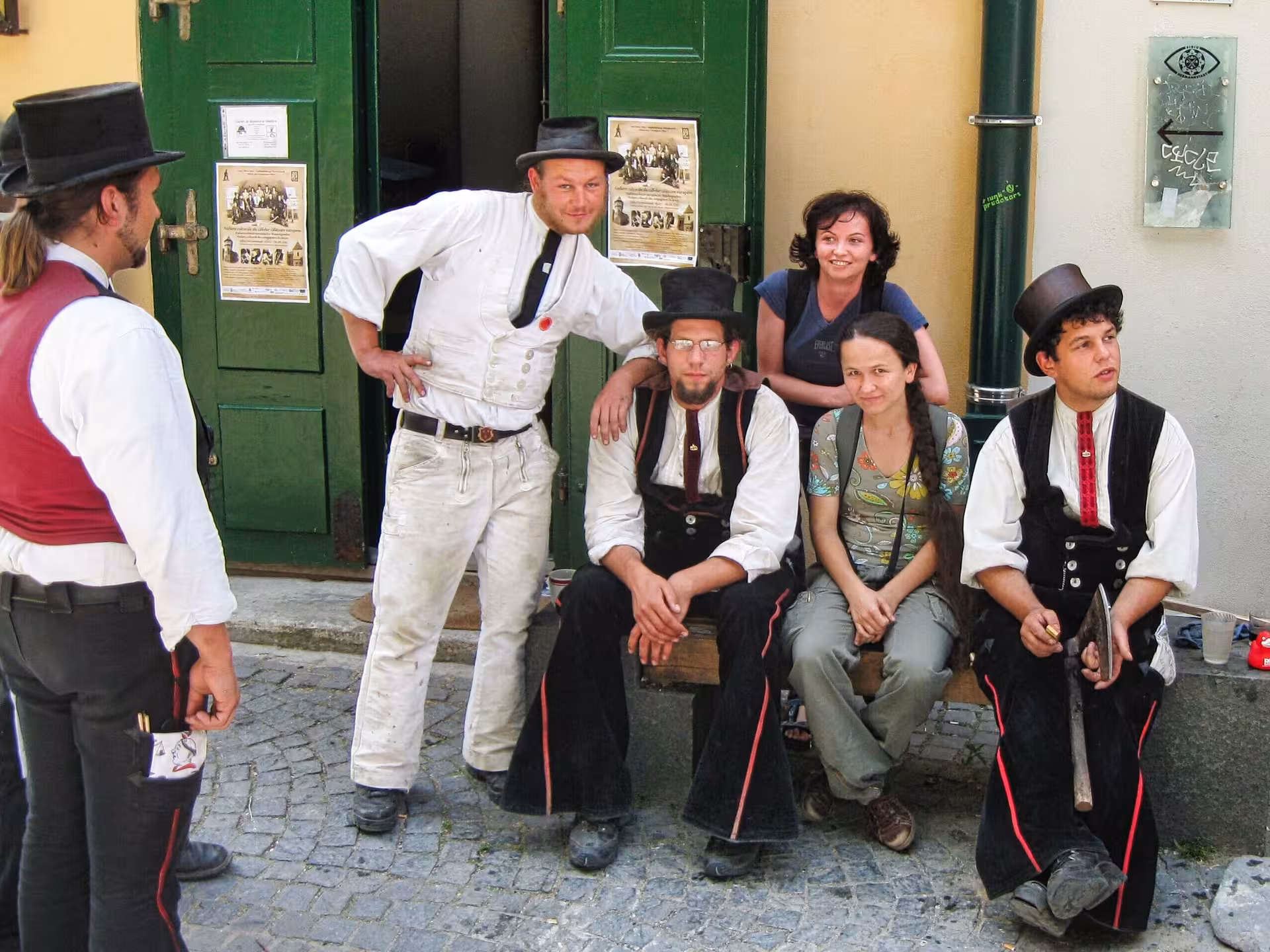 Traditional Romanian folk performers in historic costumes on cobblestone streets of Sibiu during a Cluj day trip