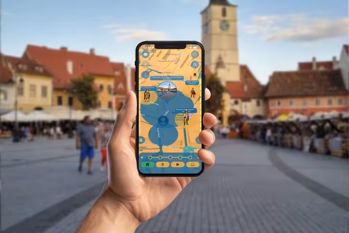 Hand holding smartphone with self-guided walking tour app map in Sibiu's historic main square
