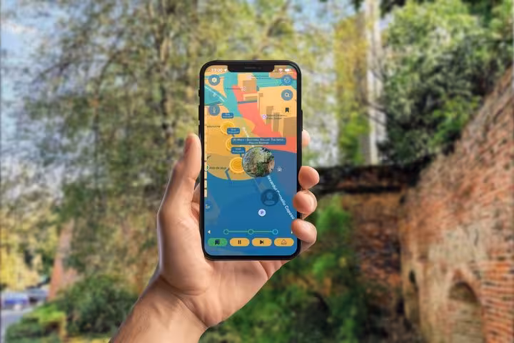 Hand holding smartphone displaying colorful interactive map for self-guided walking tour in Sibiu