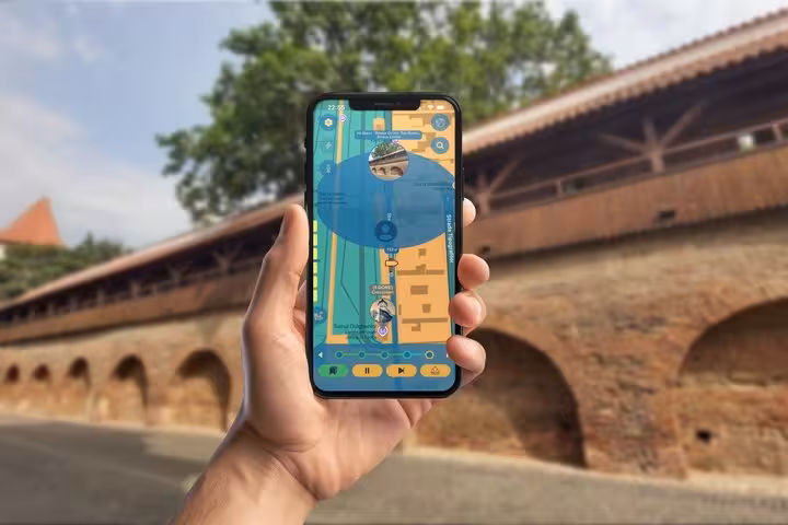 Hand holding smartphone displaying interactive map app for self-guided walking tour in Sibiu