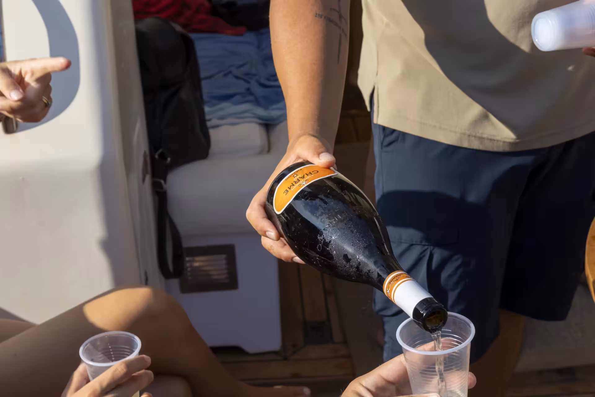 Crew pours Sicilian wine on Egadi Islands boat excursion from Trapani, with lunch included for Favignana and Levanzo