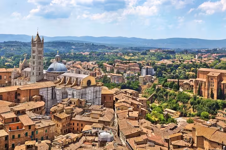 Scenic view of Siena's historic architecture and rolling hills, featured in a private Tuscany day tour from Florence.
