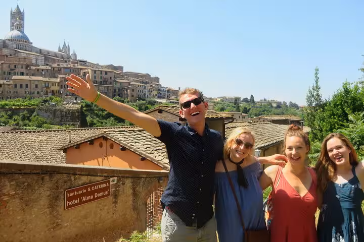 Happy tourists enjoying a sunny day in Siena's historic landscape, ideal for Tuscany small group tours and wine tasting.