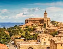 Panoramic view of Montalcino hilltop town with medieval stone buildings and church tower in Siena, Tuscany