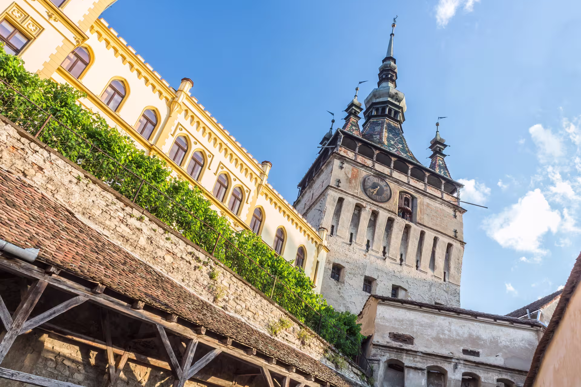 Iconic clock tower in Sighisoara under a blue sky, a highlight of the Dracula candlelight tour in Transylvania.