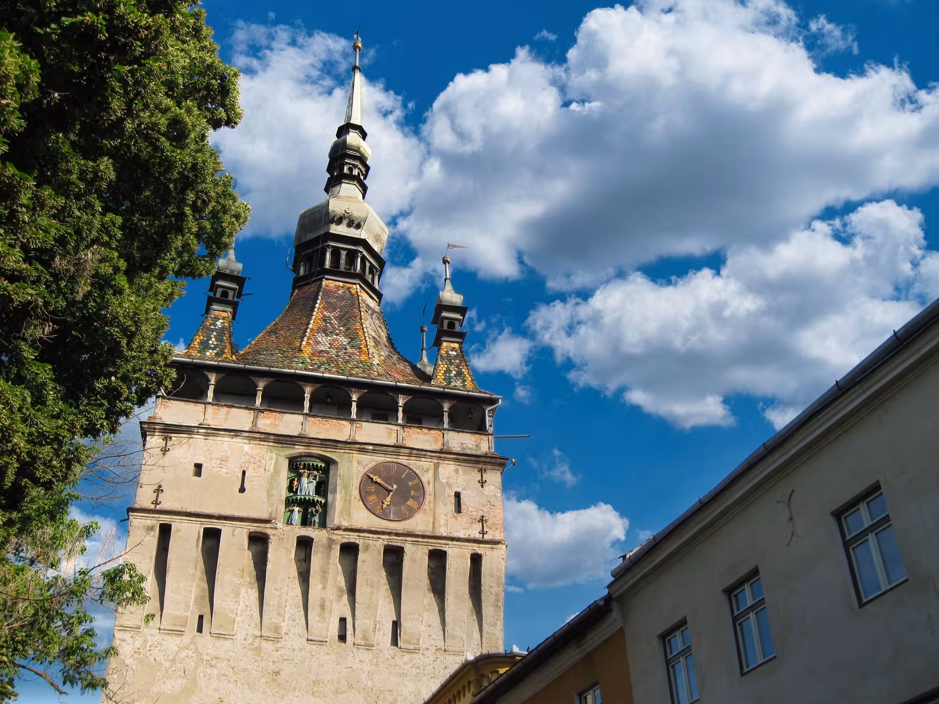 Clock Tower of Sighisoara medieval citadel with colorful tiled roof and Roman numeral clock face