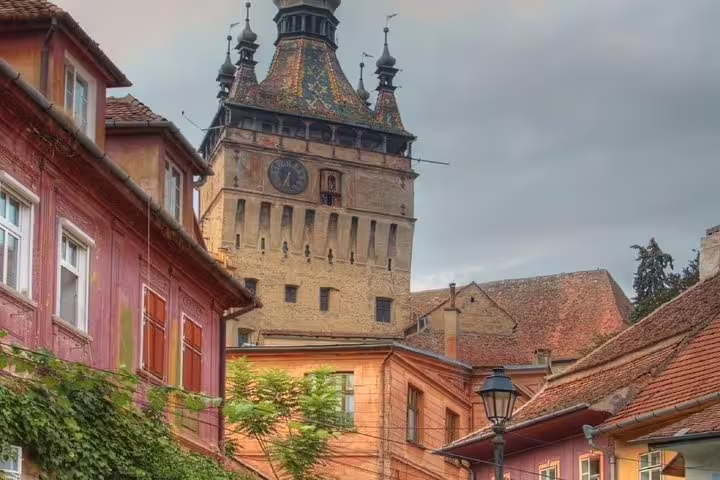 Medieval Clock Tower rising above colorful Saxon houses in Sighisoara old town, Romania