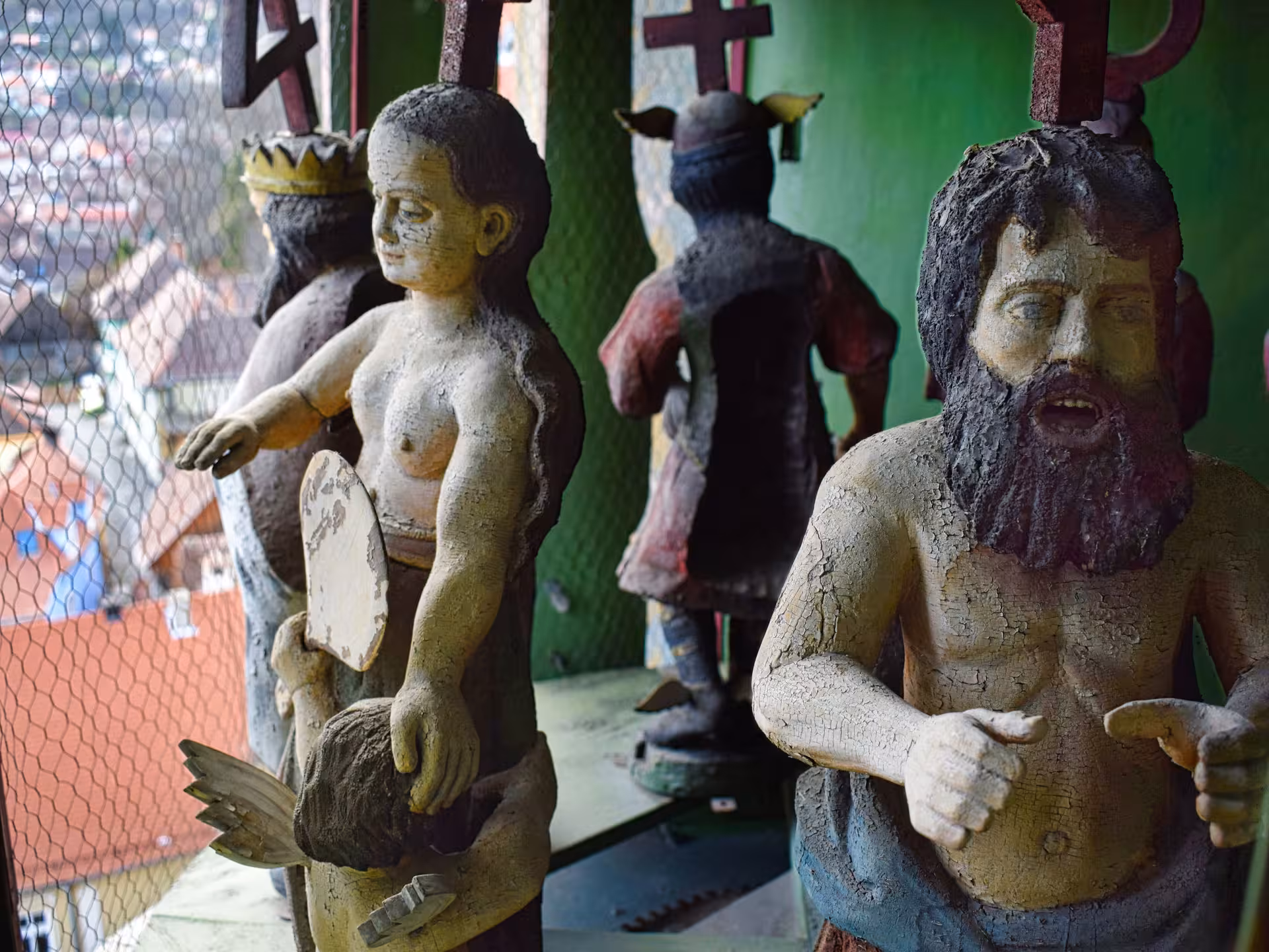 Weathered religious folk art statues with crosses in Sighisoara, Romania