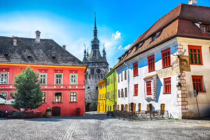 Colorful medieval buildings and clock tower in Sighisoara fortress old town square