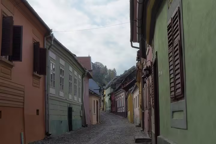 Cobblestone street lined with colorful medieval buildings in Sighisoara old town, Romania