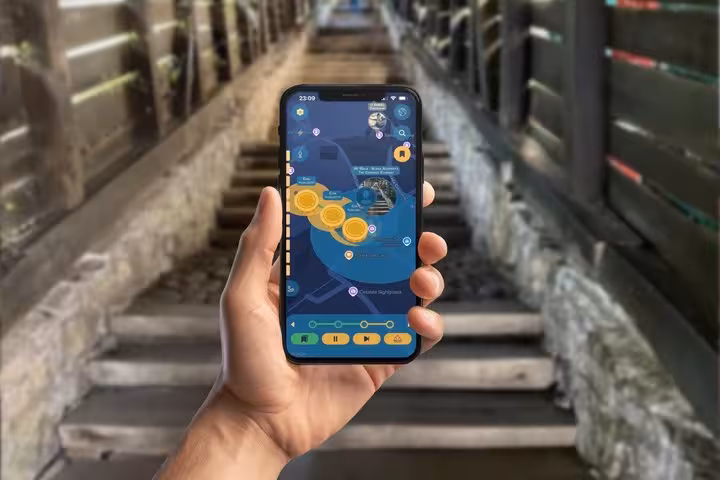 Hand holding smartphone displaying Sighisoara Saxon Citadel scavenger hunt game map with golden coins