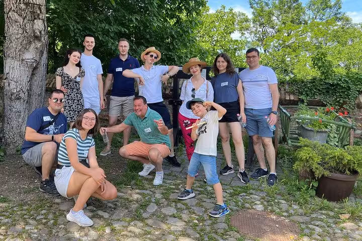 Group of tourists posing outdoors during Sighisoara walking tour adventure on cobblestone path