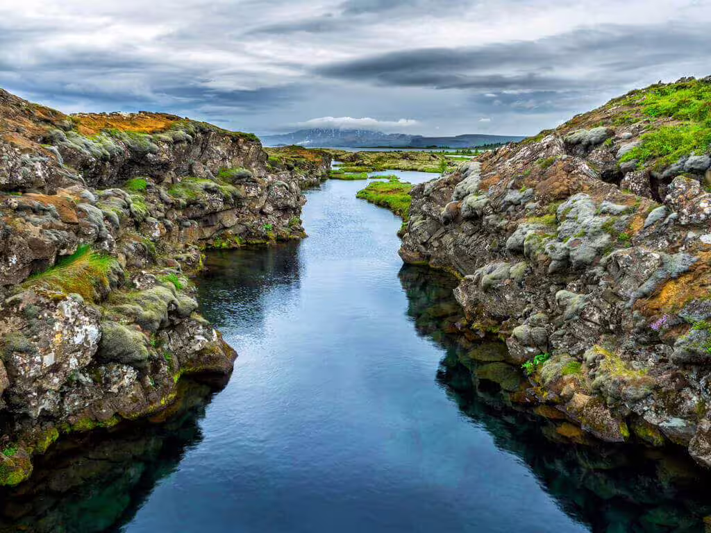 Crystal clear water flowing through mossy lava rock fissure at Silfra, Thingvellir National Park, Iceland