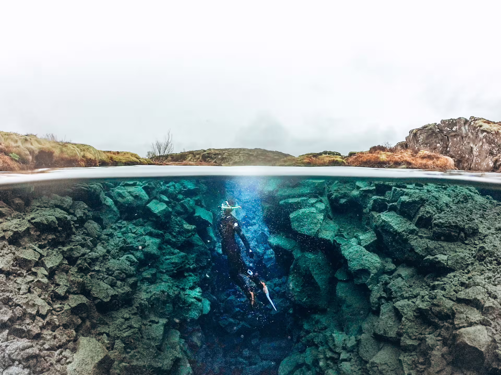 Snorkeler explores the clear waters of Silfra fissure in Iceland, highlighting the unique underwater landscape for an unforgettable adventure.