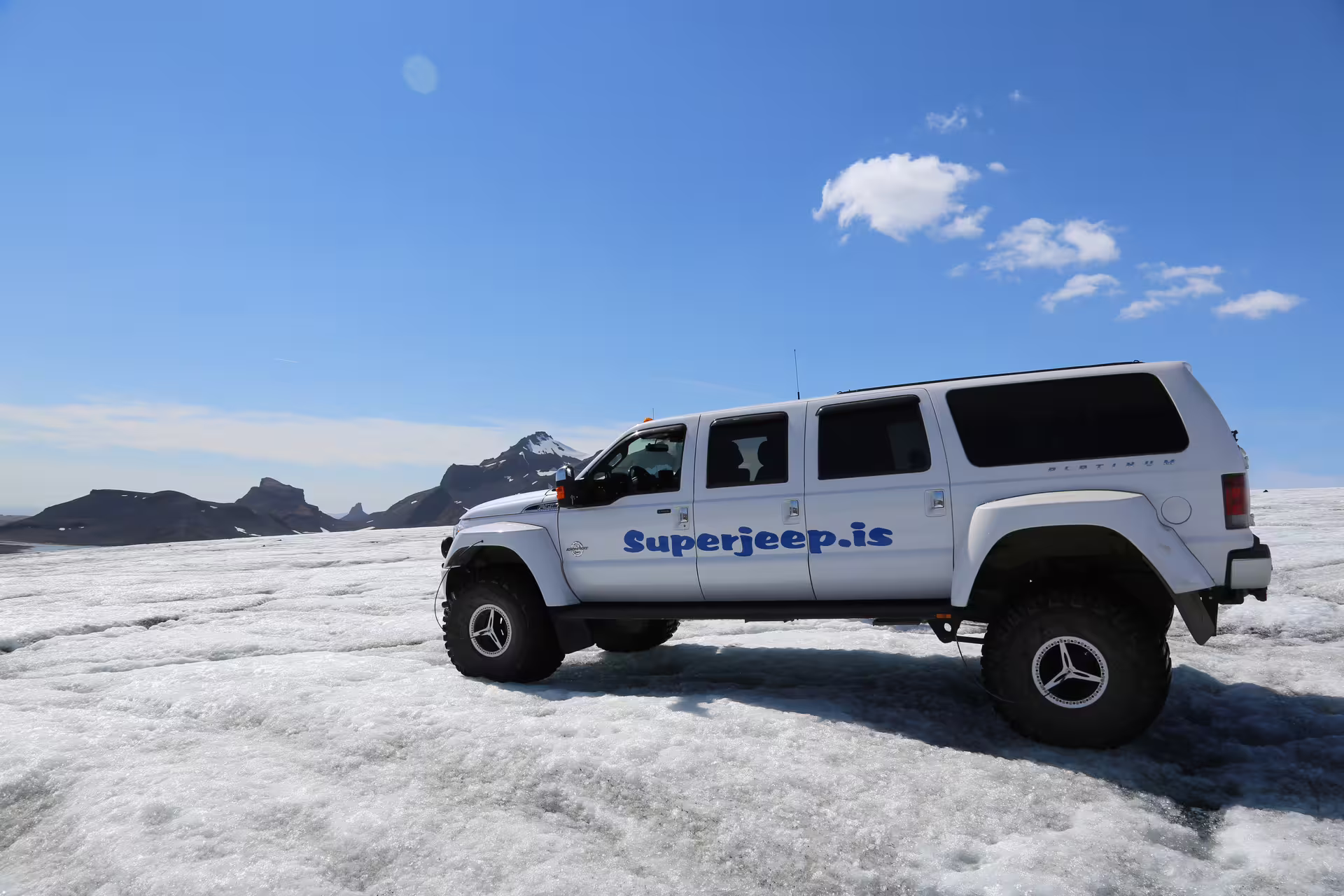 Superjeep on an Icelandic glacier under clear blue skies, featured in the Silfra Superjeep Golden Circle & Snorkeling Day Tour.