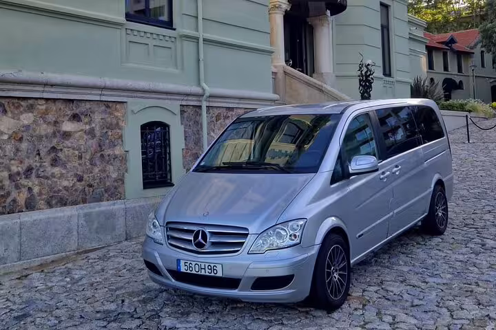 Silver Mercedes van parked on cobblestone street, perfect for private transfer between Porto and Santiago.