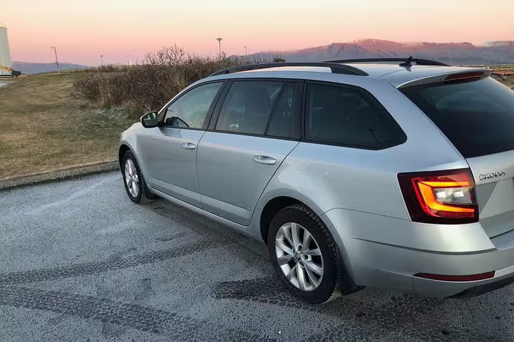 Silver Skoda estate car parked at sunset near Reykjavik Iceland landscape
