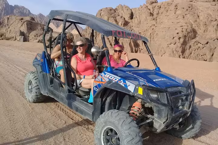 Friends riding a buggy in Sinai Desert on a private adventure tour from Sharm El Sheikh, rocky backdrop