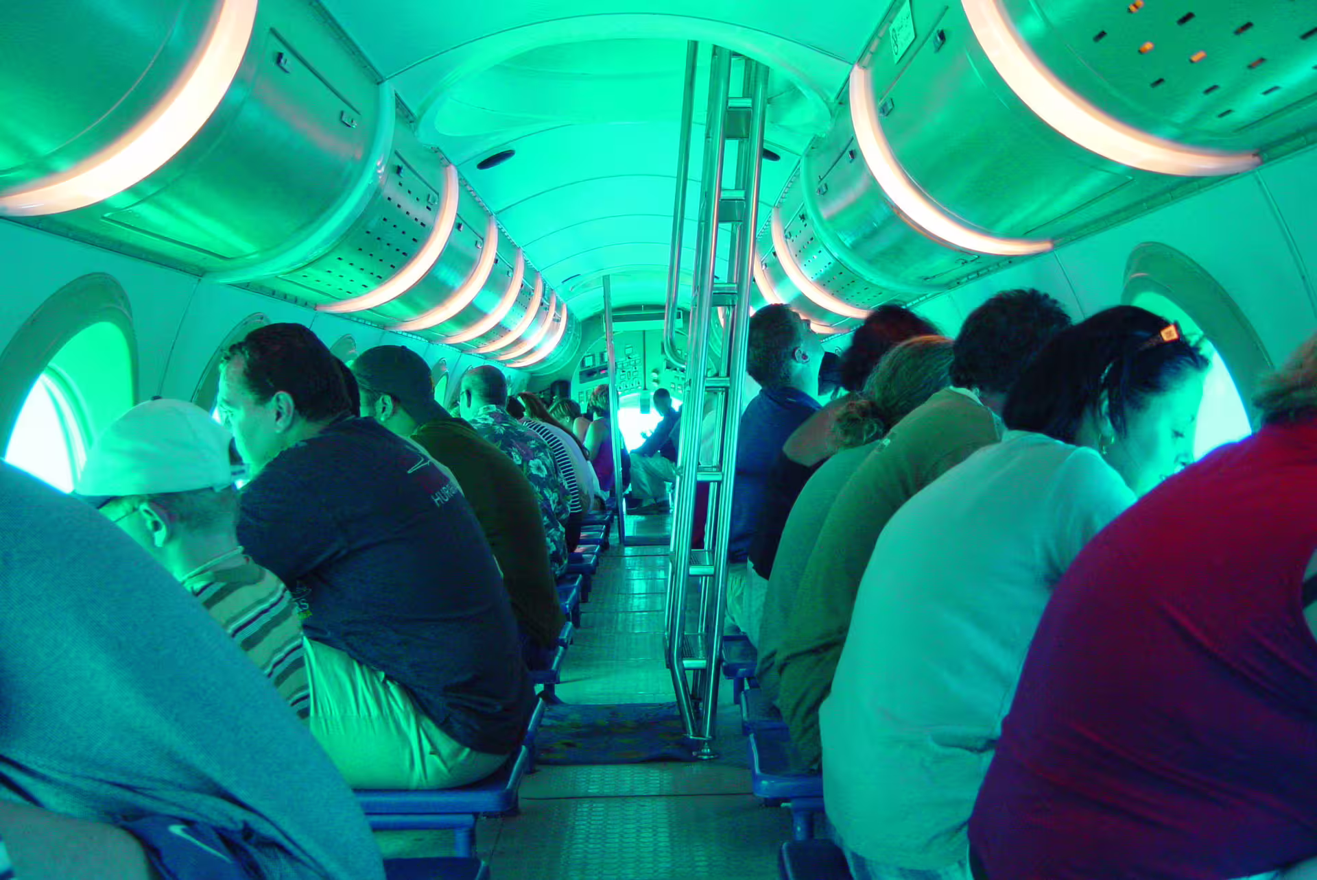 Inside Sindbad submarine cabin with passengers at portholes, Red Sea underwater viewing tour in Hurghada