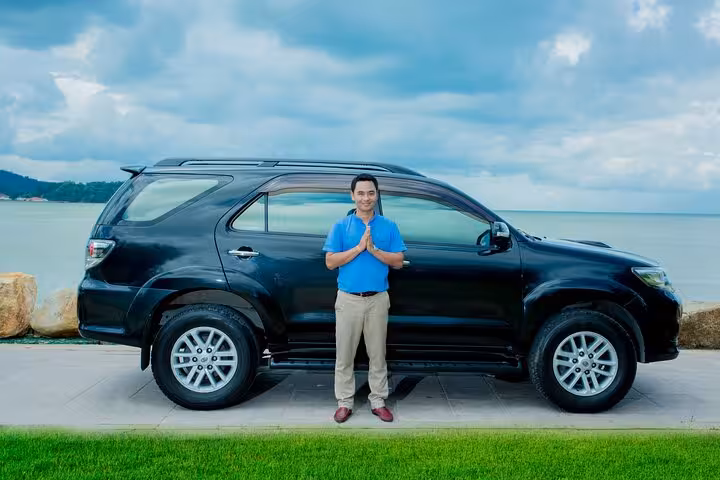 Professional driver beside black SUV for Singapore airport private transfer, safe door-to-door pickup service