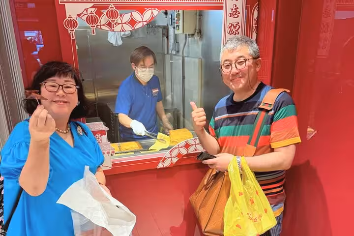 Delight in sampling local delicacies at a hawker stall in Singapore's Chinatown during the Free eSIM food tour experience.