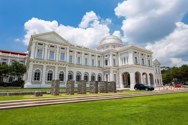 National Museum of Singapore white colonial building with dome and green lawn on sunny day