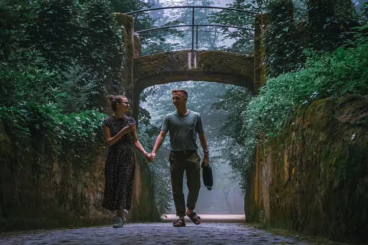 Couple strolling through lush greenery in Sintra's Palace Regaleira on a private tour of Sintra, Cascais, and Estoril.